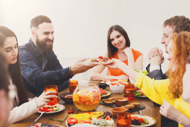istock Group of happy people at festive table dinner party 871189788