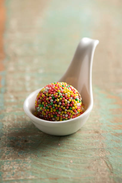 Brigadeiro with colorful beads on a spoon, Brazilian sweet delight made with condensed milk, and chocolate.