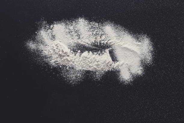 istock Sprinkled wheat flour splash spots on black background 871193286