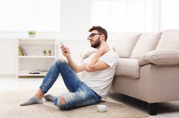 istock Young man at home with mobile feel pain 871193580