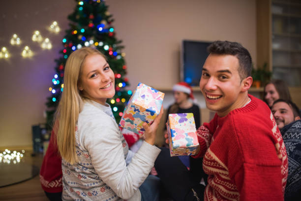 istock Two friends holding gifts camera 871203158