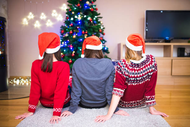 istock Friends sitting in front of Christmas tree 871203180
