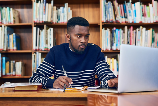 Cropped shot of a university student doing some research on a laptop