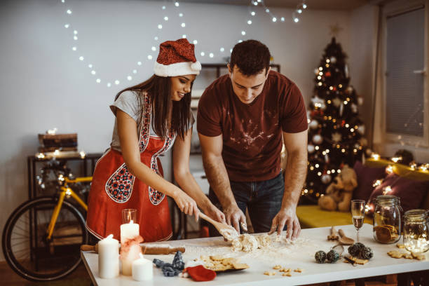 istock Young couple making christmas cookie from dough in the kitchen 871207956
