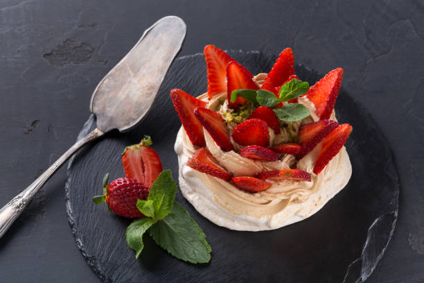 istock Anna Pavlova cake with strawberry on black background 871208212