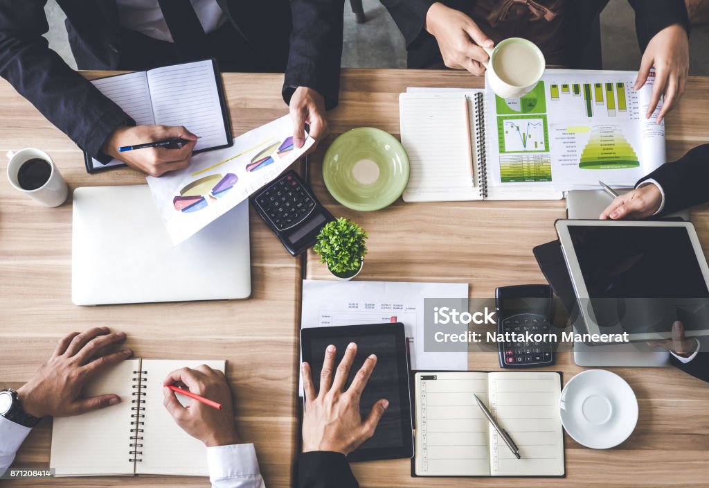 Meeting table/desk top view, businessman talking about business plan, progress report for business work, financial report, status, tablet, coffee, on the table, discussing with colleague at office Business Meeting Stock Photo