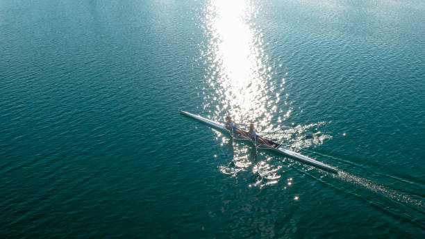 istock Two female athletes sculling on lake in sunshine 871208972