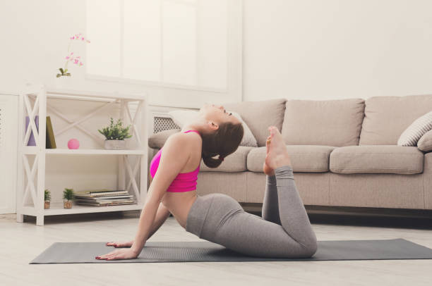 istock Woman training yoga in bow pose. 871211740