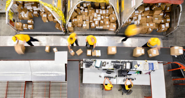 Boxes on conveyor belt Workers processing boxes on conveyor belt in distribution warehouse, blurred motion. production line stock pictures, royalty-free photos & images