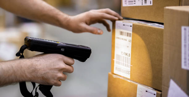 Manual worker scanning cardboard box Male worker scanning cardboard with barcode reader at warehouse. bar code reader stock pictures, royalty-free photos & images