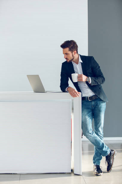 istock Thoughtful young businessman using laptop looking for new ideas. 871217558