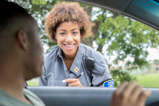 oficial de policía amable habla con conductor trenzado - car stranded women breakdown fotografías e imágenes de stock