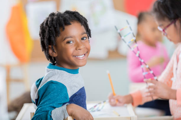 istock Cheerful little boy pauses from school work to smile for camera 871226616