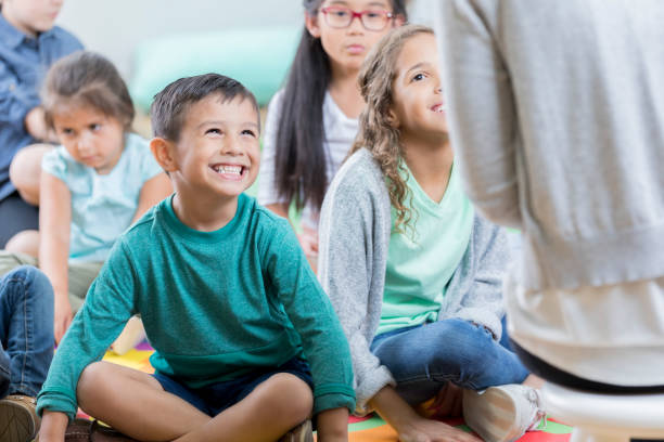 istock Unrecognizable teacher sits on stool before group of students 871226642
