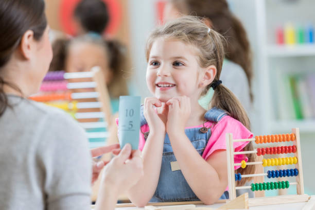 istock Attentive little girl enjoys math lesson with tutor 871226654