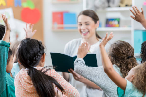 istock Group of schoolchildren raise hands for teacher 871226656
