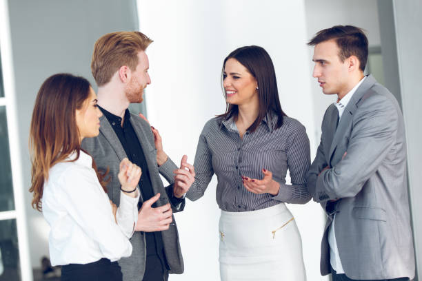 istock Four business people discussing business issues in office hallway. 871232016