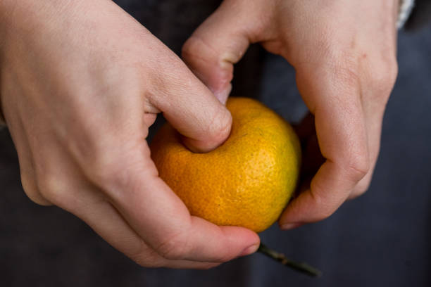 istock Close up male hands peel tangerine 871235082
