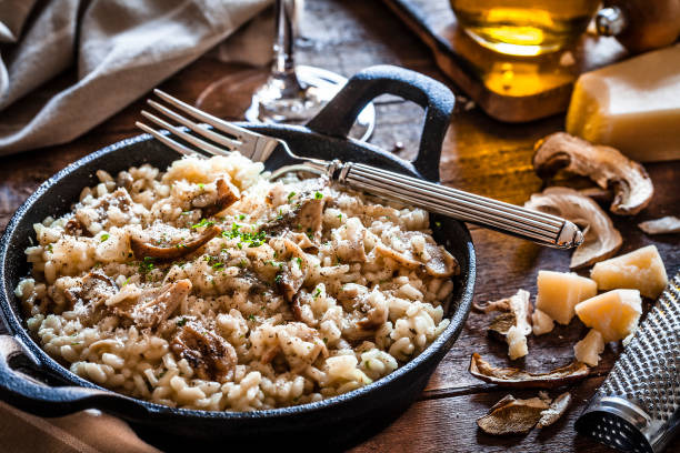 risotto hongos porcini en mesa de madera rústica - arroz arborio fotografías e imágenes de stock