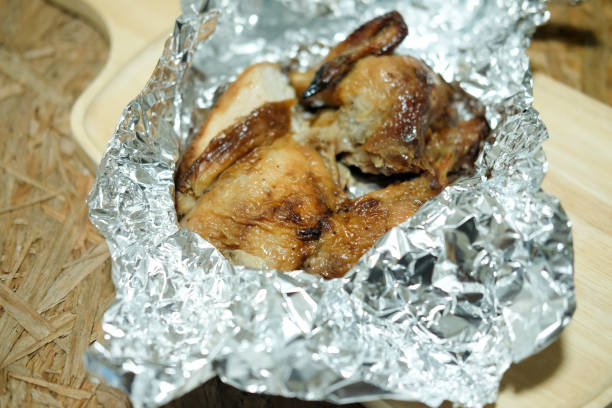 istock Whole roasted chicken on foil with wood background 871243842