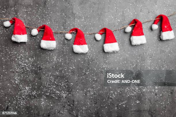 Sombreros De Santa De Navidad Sobre Fondo Rústico Con Espacio De Copia Foto de stock y más banco de imágenes de Adviento