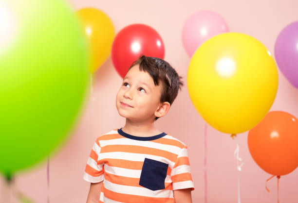 Cute child among colorful balloons.