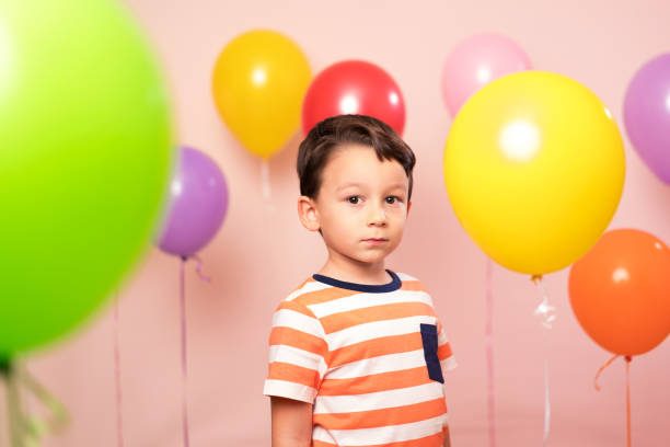 istock Cute child among colorful balloons. 871255518
