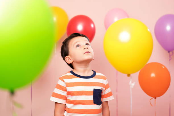 istock Cute child among colorful balloons. 871255618