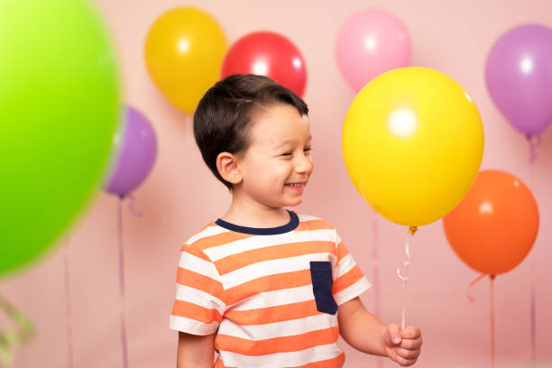 istock Cute child among colorful balloons. 871256008