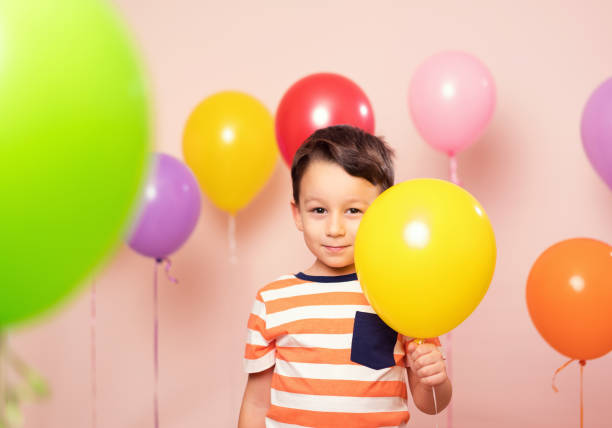 istock Cute child among colorful balloons. 871257230