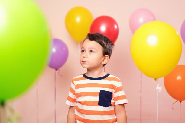 istock Cute child among colorful balloons. 871257962