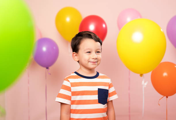 istock Cute child among colorful balloons. 871258482