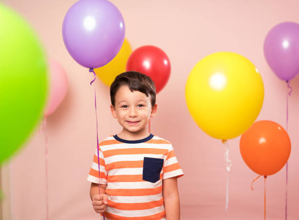 istock Cute child among colorful balloons. 871258492