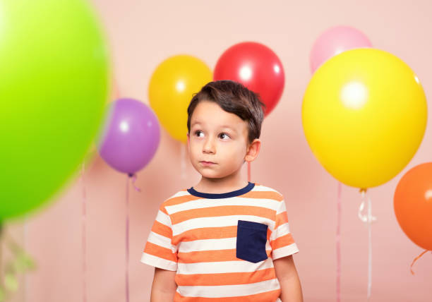 istock Cute child among colorful balloons. 871259016