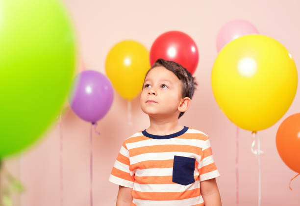istock Cute child among colorful balloons. 871259028
