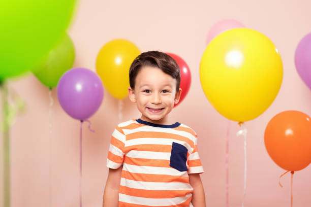 istock Cute child among colorful balloons. 871259380