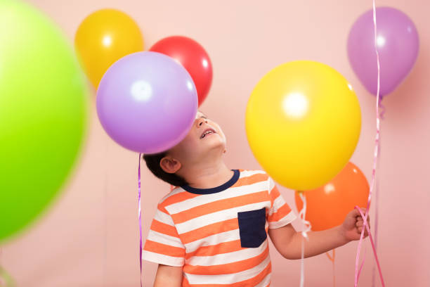 istock Cute child among colorful balloons. 871259516