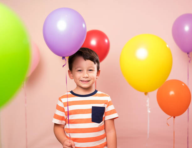 istock Cute child among colorful balloons. 871259738