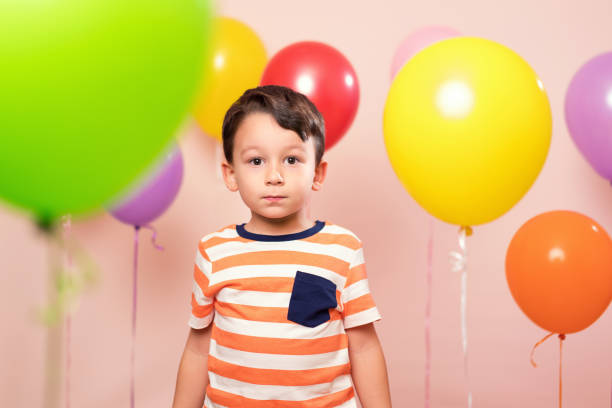 istock Cute child among colorful balloons. 871259744