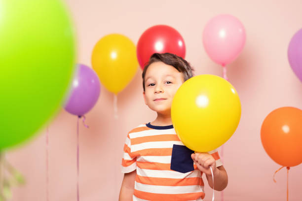 istock Cute child among colorful balloons. 871260032