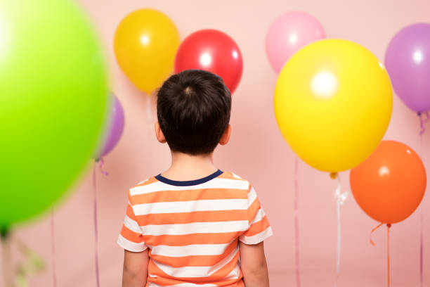 istock Cute child among colorful balloons. 871260036