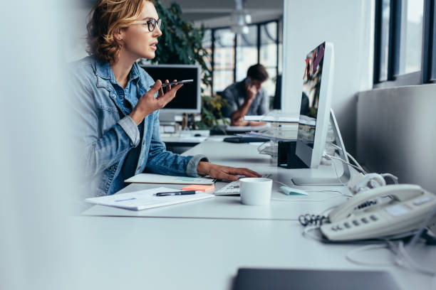 istock Businesswoman talking on phone and working on computer 871262488