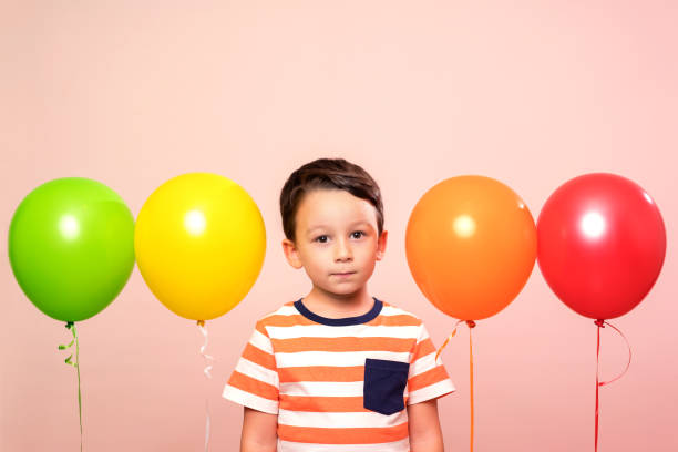 istock Cute child among colorful balloons. 871262658