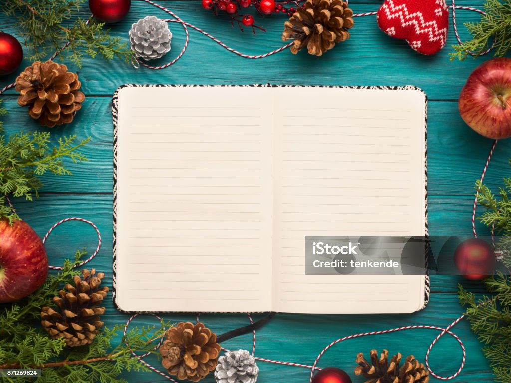 Open notebook on christmas background Open notebook on christmas background with pine cones and ornaments. Festive flat lay with white pages Christmas Stock Photo