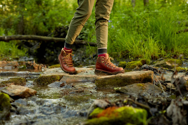 istock Female hiker crossing a small mountain stream 871271880