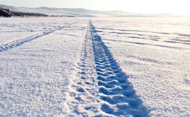 traces de pneus dans la neige sur la surface de glace de lac baïkal - winter cold footpath footprint photos et images de collection