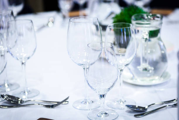 istock Transparent glasses on a banquet table with spoons and forks. 871272926