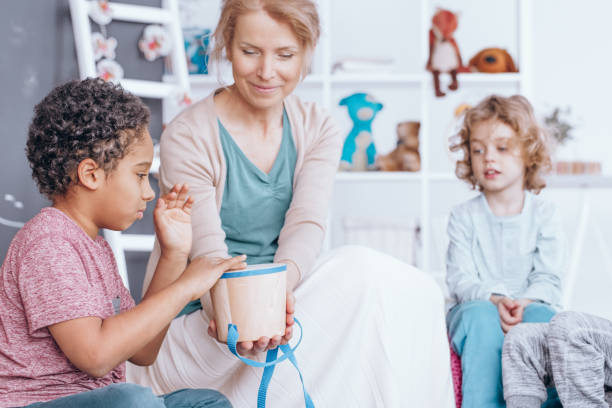 African-american boy choosing award African-american boy choosing award for correctly done logical exercise in kindergarten morning time management for preschool for babies stock pictures, royalty-free photos & images