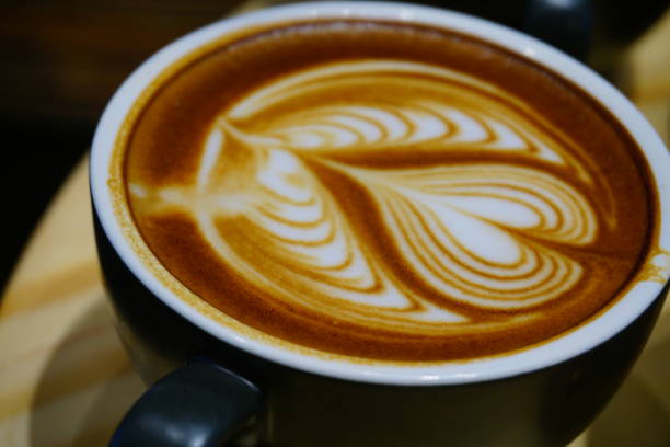 istock Cup of cafe' latte with coffee beans and cinnamon sticks 871273950