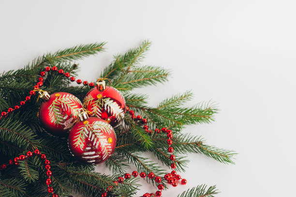 istock Red balls on fir branches on a white background 871280278